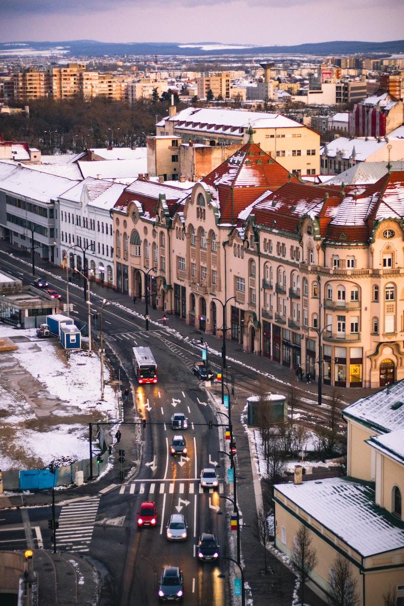 a city street filled with lots of traffic next to tall buildings