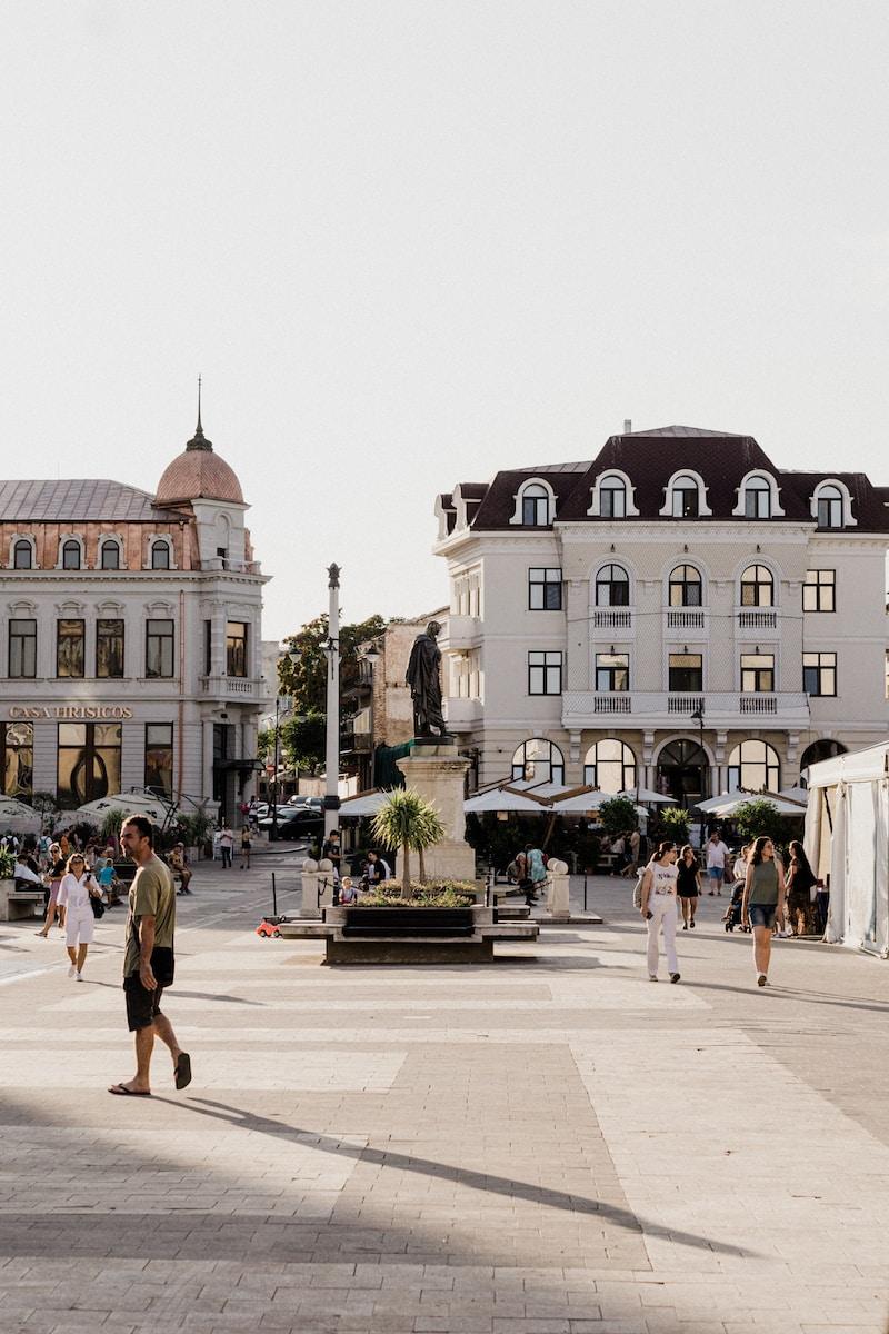 Photo by Matei Pruteanu people walking on sidewalk near white concrete building during daytime