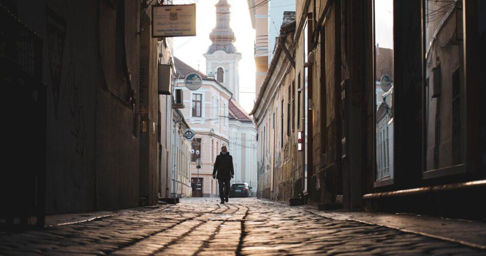 man in black jacket walking on street during daytime