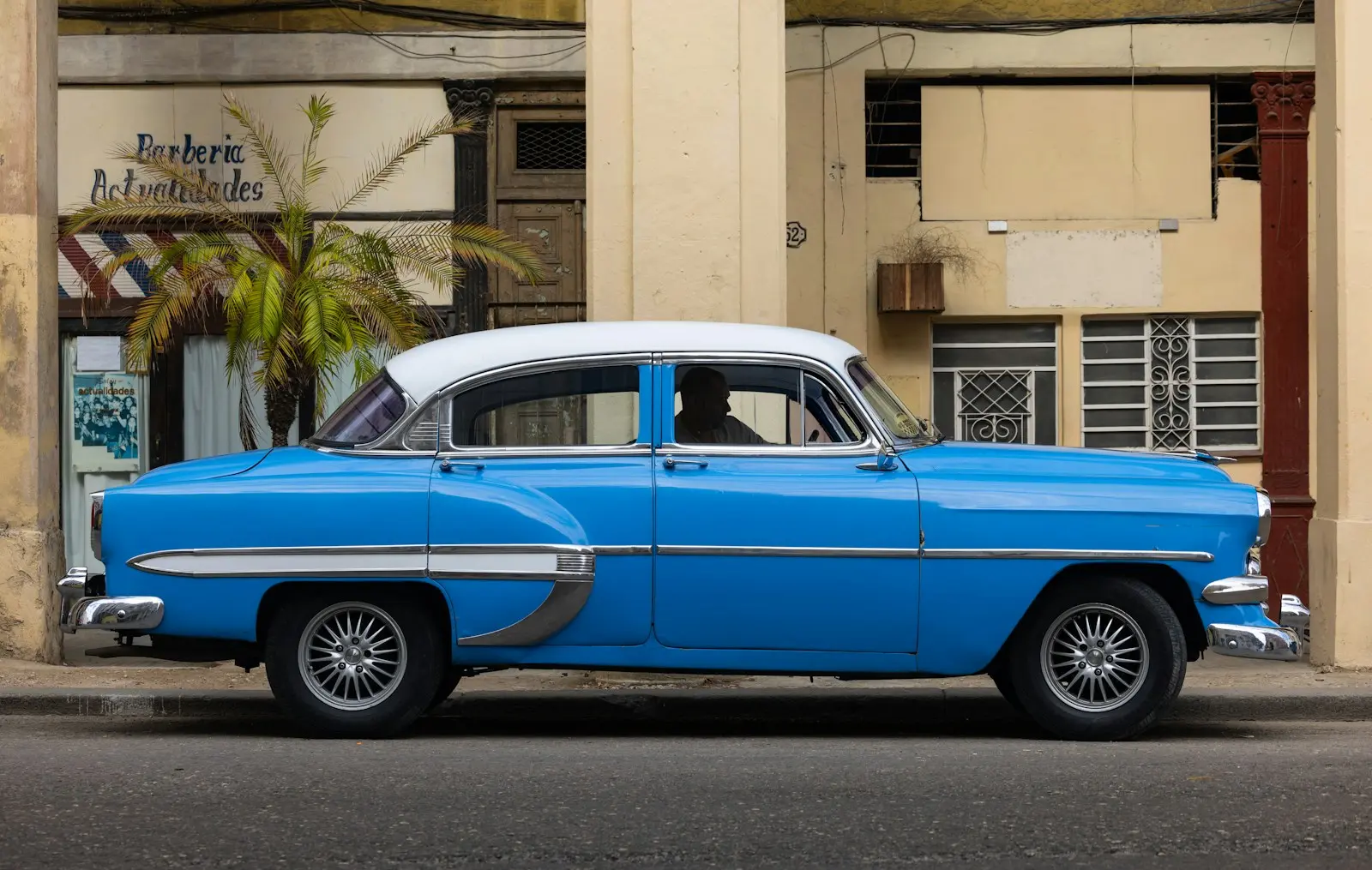 Photo by Matthew Davis a blue and white classic car parked in front of a building