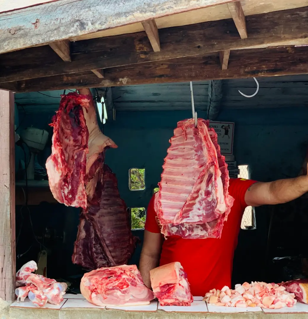 Photo by XH S man standing in front of hanged meat
