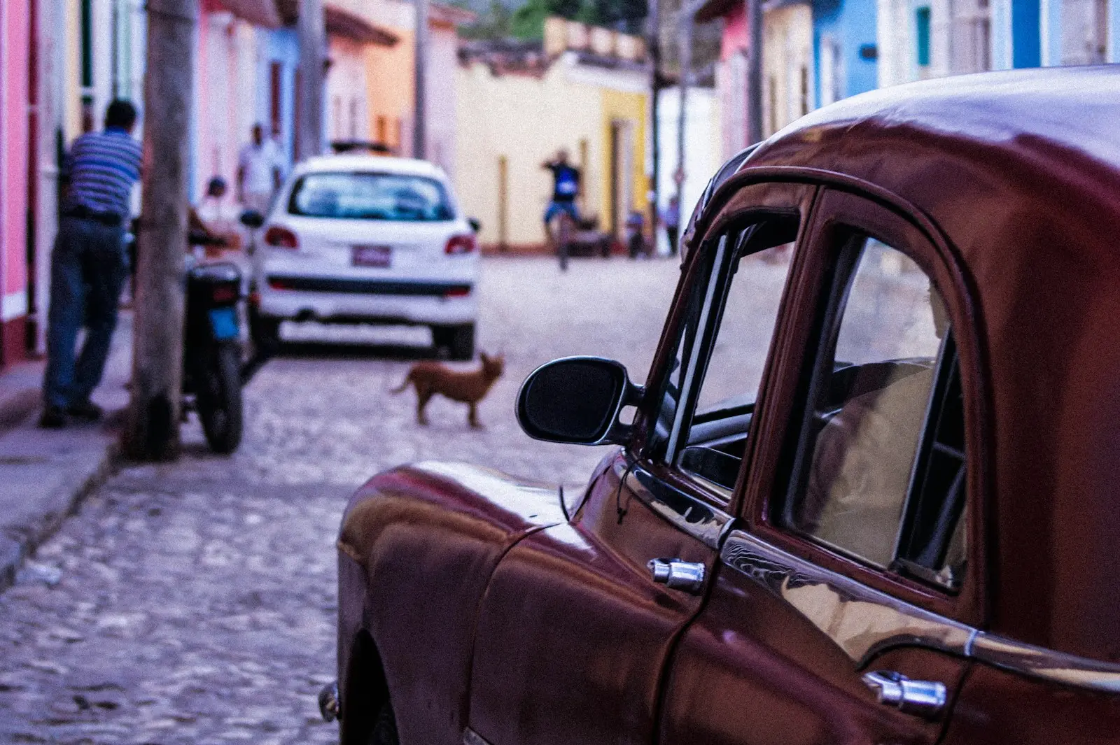 Photo by Ellie Cooper a red car parked on the side of a street