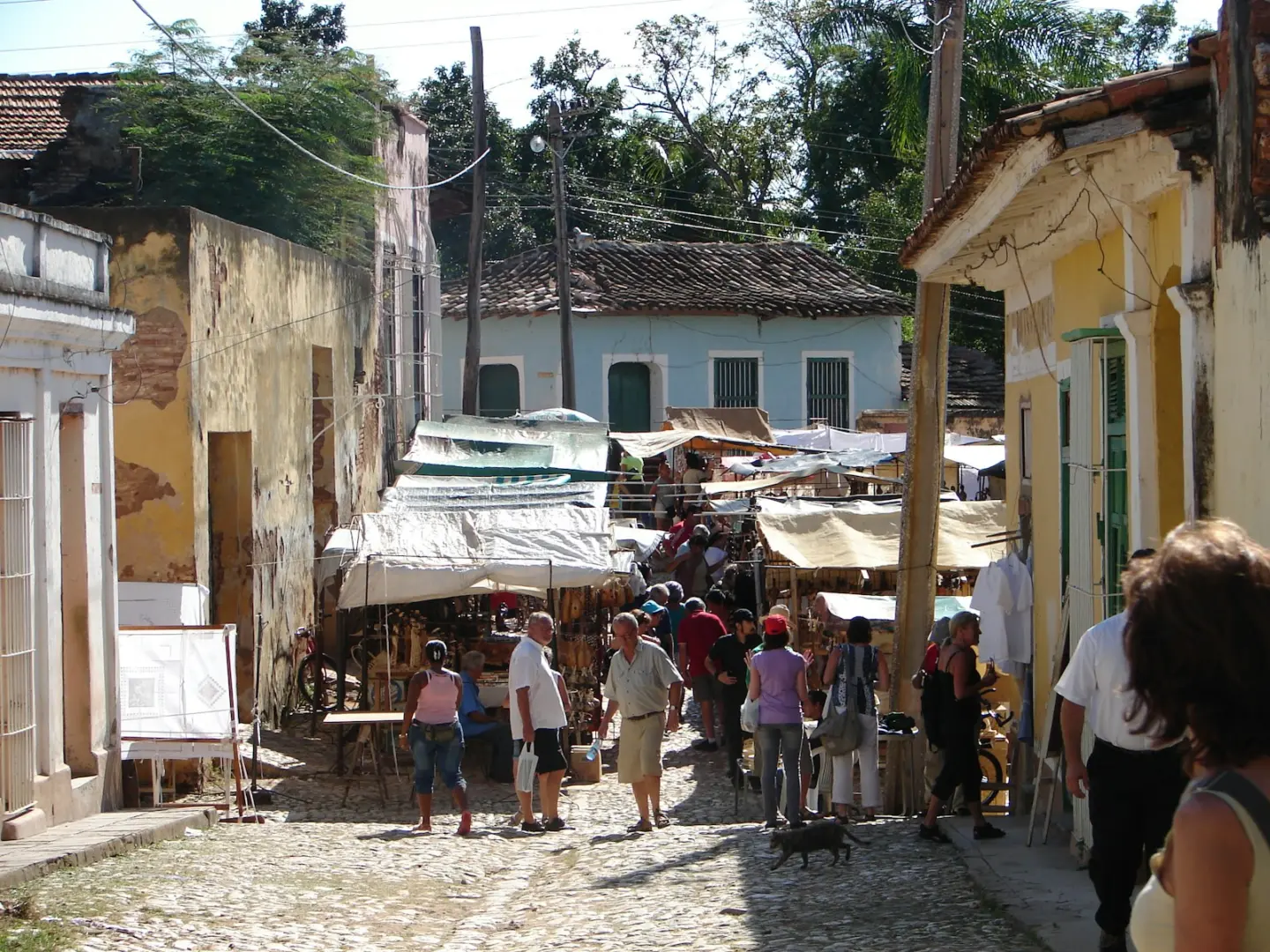 Photo by Carlos Aprea a group of people walking down a street next to buildings